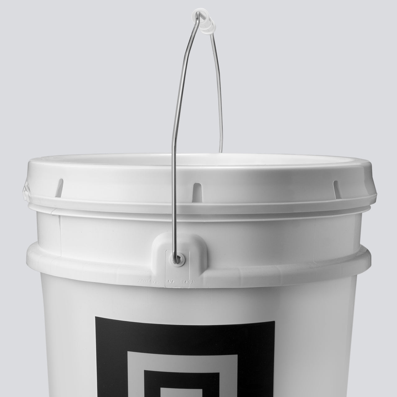 A close up of the lid of a white bucket filled with chalk