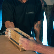2 people pinching a wooden see saw