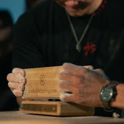 2 people pinching a wooden see saw