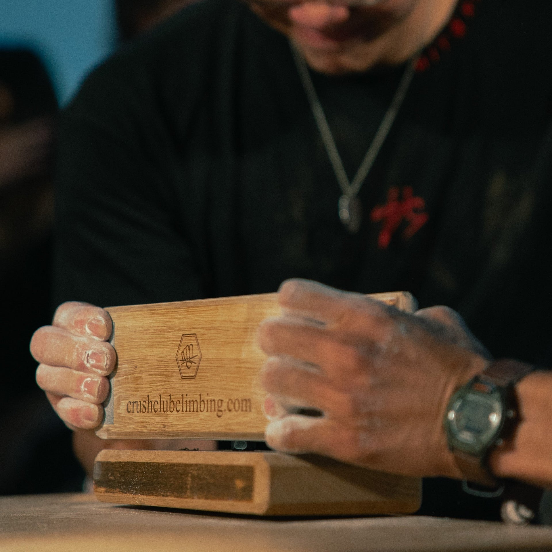 2 people pinching a wooden see saw