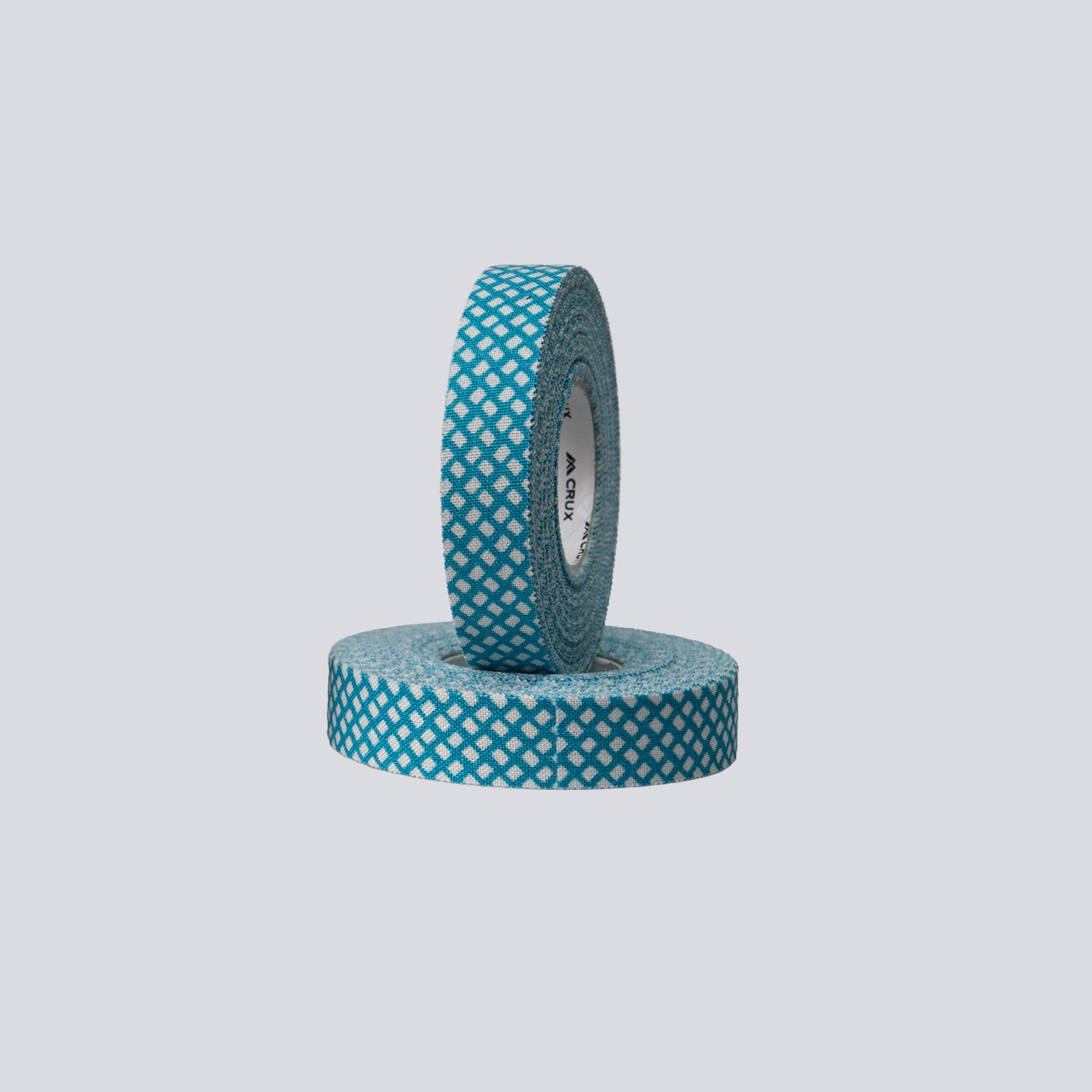Two rolls of teal tape with white pattern on a light gray background