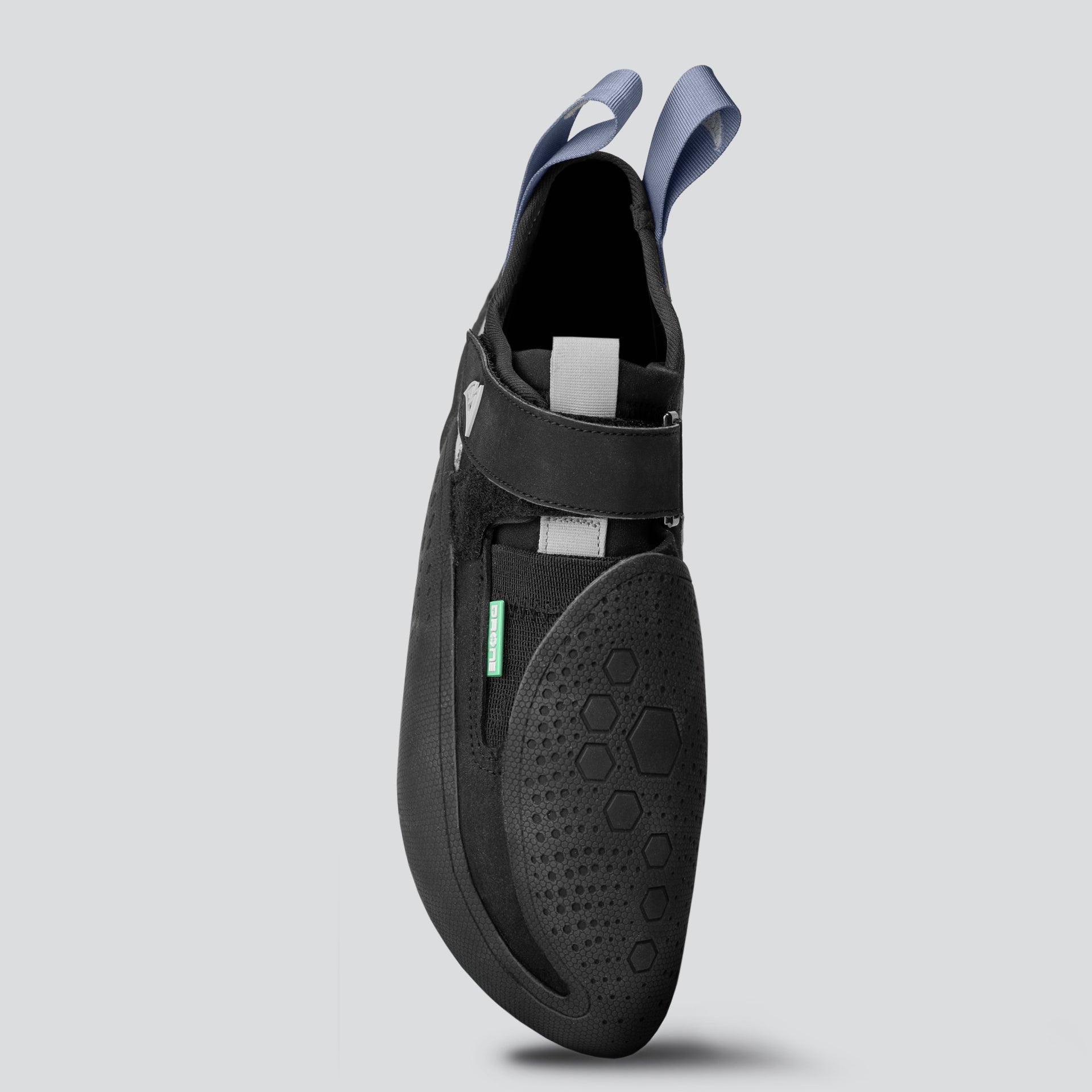 Top view of a black climbing shoe with gray and teal accents on a light gray background