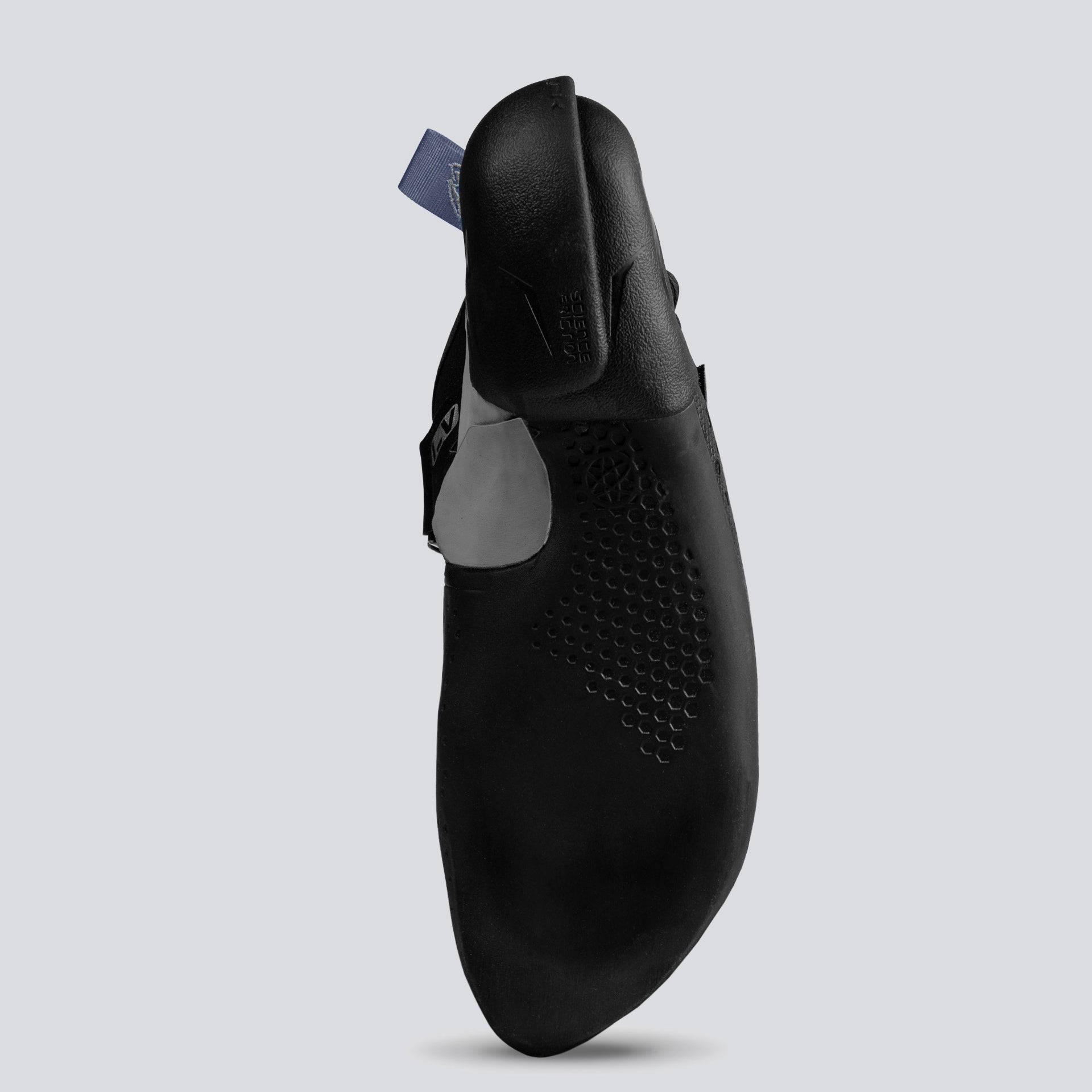 Bottom of a black climbing shoe with gray and teal accents on a light gray background