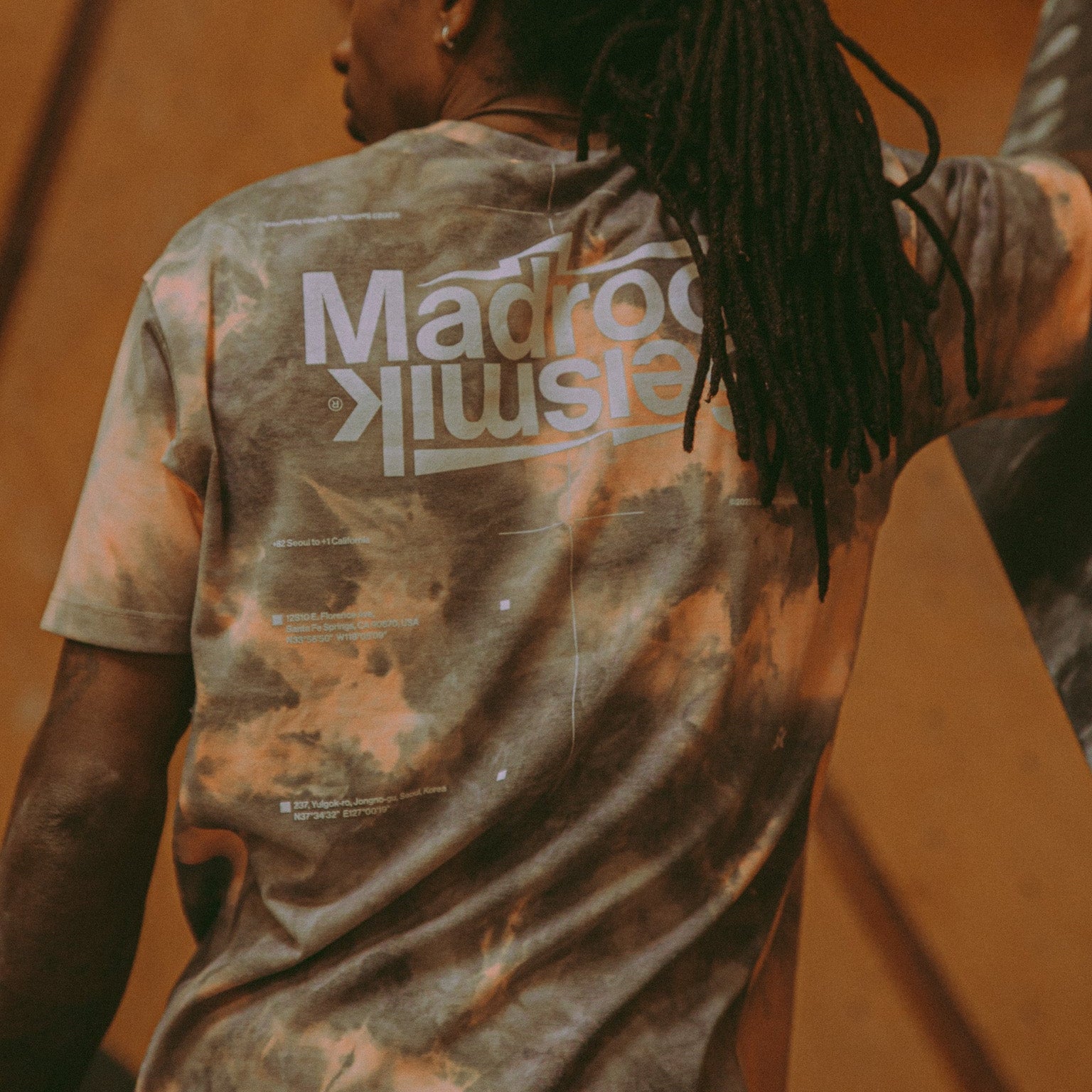 athlete Mickael Mawem wearing an acid wash shirt facing away from the camera