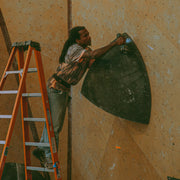 athlete Mickael Mawem wearing an acid wash shirt and drilling a large volume into a wall