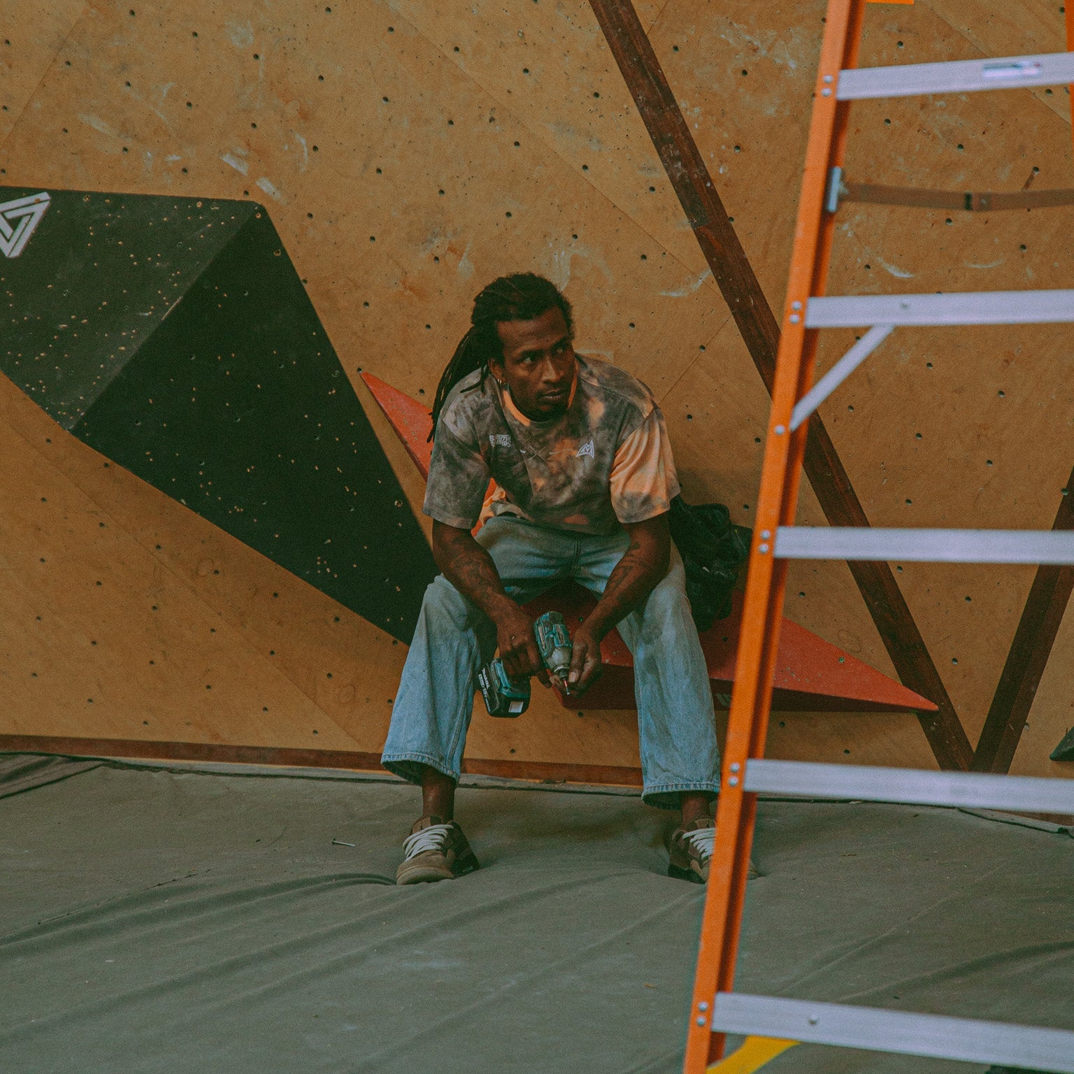 athlete Mickael Mawem wearing an acid wash shirt while sitting on a volume