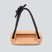 Wooden training block with a black cord on a light gray background