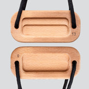 A view of a wooden training block highlighting the 8 millimeter edge depth and 13 millimeter edge depth with a black cord on a light gray background